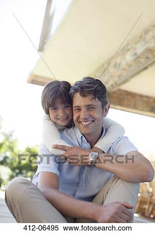 Stock Photography - Father and daughter sitting together outdoors. Fotosearch