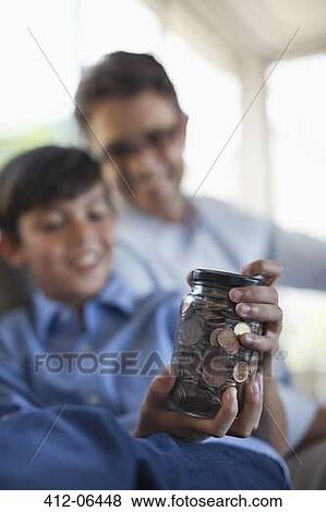 Father and son holding change jar View Large Photo Image Stock Photo - Father and son holding change jar. Fotosearch