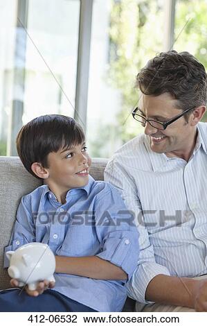 Father and son holding piggy bank View Large Photo Image Stock Image - Father and son holding piggy bank. Fotosearch