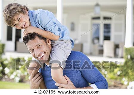 Stock Photography - Father and son playing outside house. Fotosearch