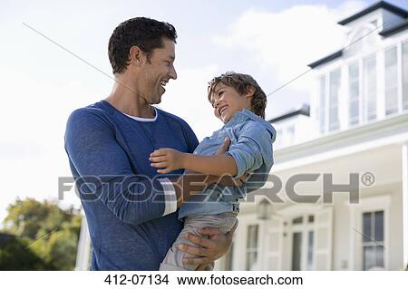 Father and son smiling outside house View Large Photo Image Picture - Father and son smiling outside house. Fotosearch