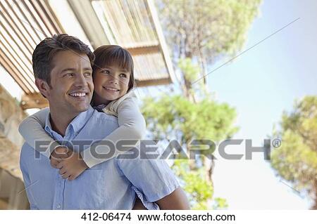 Father carrying daughter piggy back outdoors View Large Photo Image Picture - Father carrying daughter piggy back outdoors. Fotosearch