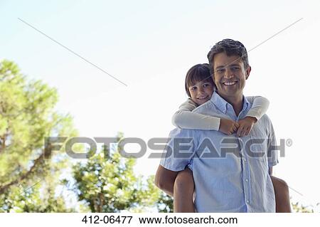 Father carrying daughter piggy back outdoors View Large Photo Image Stock Photo - Father carrying daughter piggy back outdoors. Fotosearch