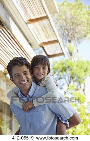 Father carrying daughter piggy back outdoors View Large Photo Image Stock Photo - Father carrying daughter piggy back outdoors. Fotosearch