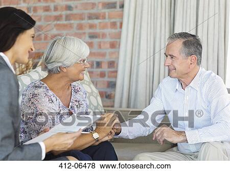 Financial advisor talking to couple on sofa View Large Photo Image Stock Photo - Financial advisor talking to couple on sofa. Fotosearch