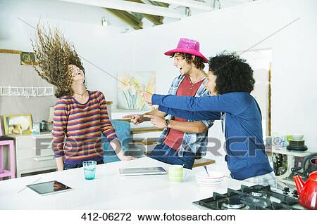 Friends playing together in kitchen View Large Photo Image Stock Image - Friends playing together in kitchen. Fotosearch