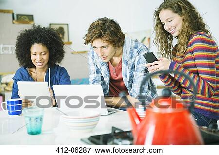 Friends relaxing together in kitchen View Large Photo Image Stock Photo - Friends relaxing together in kitchen. Fotosearch