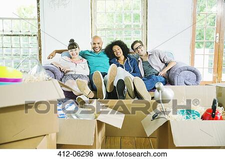 Friends relaxing together in new home View Large Photo Image Stock Photo - Friends relaxing together in new home. Fotosearch