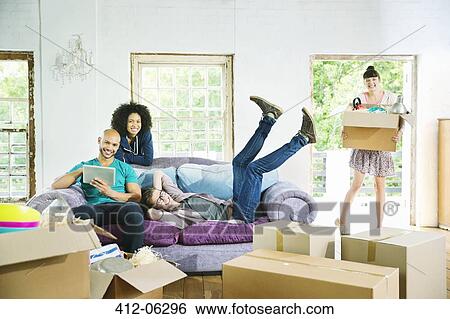 Friends relaxing together in new home View Large Photo Image Stock Photograph - Friends relaxing together in new home. Fotosearch