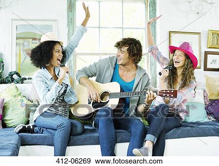 Stock Photo - Friends singing and playing music together. Fotosearch
