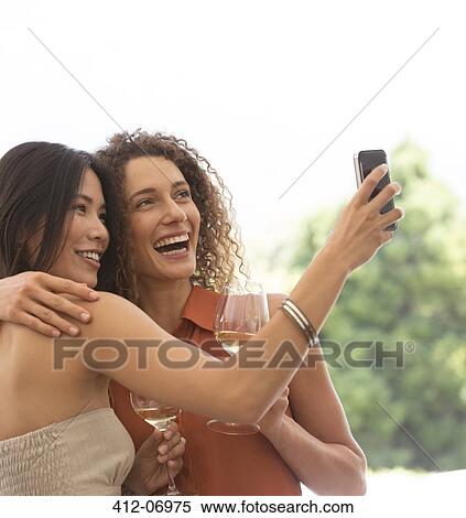 Friends taking pictures together outdoors View Large Photo Image Stock Photography - Friends taking pictures together outdoors. Fotosearch