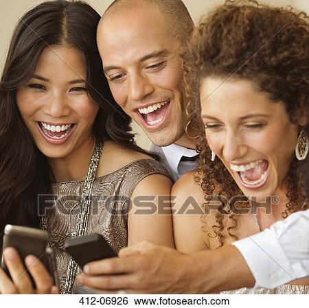 Stock Photograph - Friends using cell phones together. Fotosearch