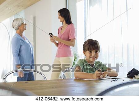 Girl doing homework at table View Large Photo Image Stock Image - Girl doing homework at table. Fotosearch
