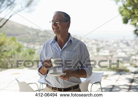 Picture - Man drinking cup of coffee outdoors. Fotosearch