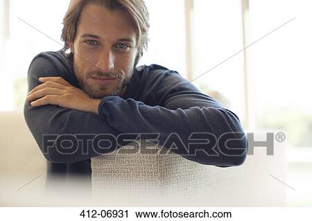 Man leaning on arm of sofa View Large Photo Image Stock Image - Man leaning on arm of sofa. Fotosearch