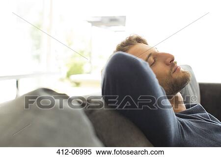Man relaxing on sofa View Large Photo Image Stock Photography - Man relaxing on sofa. Fotosearch
