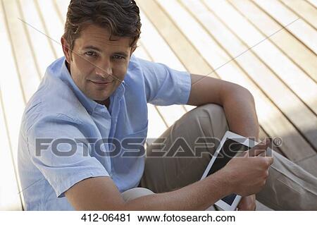 Man using tablet computer on porch View Large Photo Image Stock Image - Man using tablet computer on porch. Fotosearch
