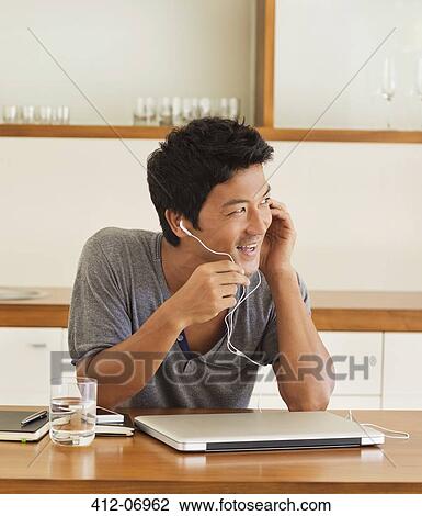Man wearing headset at table View Large Photo Image Stock Image - Man wearing headset at table. Fotosearch