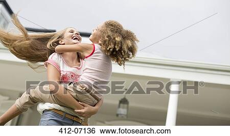 Stock Photograph - Mother and daughter playing outdoors. Fotosearch