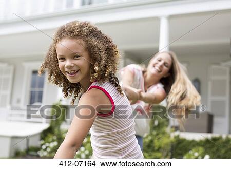 Mother and daughter playing outside house View Large Photo Image Picture - Mother and daughter playing outside house. Fotosearch