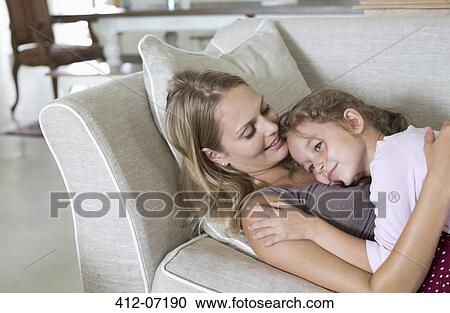 Mother and daughter relaxing on sofa View Large Photo Image Stock Image - Mother and daughter relaxing on sofa. Fotosearch