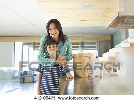 Mother hugging son in kitchen View Large Photo Image Stock Photography - Mother hugging son in kitchen. Fotosearch