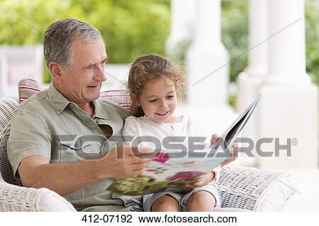 Older man reading to granddaughter on porch View Large Photo Image Stock Image - Older man reading to granddaughter on porch. Fotosearch