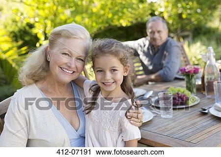 Stock Image - Older woman and granddaughter smiling outdoors. Fotosearch