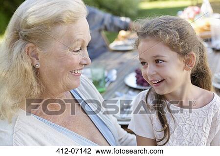 Older woman sitting with granddaughter outdoors View Large Photo Image Stock Image - Older woman sitting with granddaughter outdoors. Fotosearch