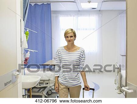 Patient wheeling luggage out of hospital room View Large Photo Image Stock Photograph - Patient wheeling luggage out of hospital room. Fotosearch