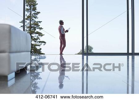 Stock Image - Reflection of businesswoman on office floor. Fotosearch