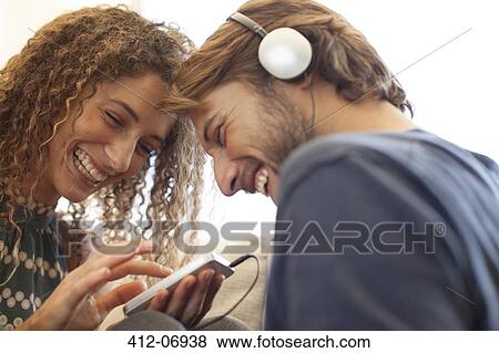 Smiling couple listening to headphones View Large Photo Image Stock Photo - Smiling couple listening to headphones. Fotosearch