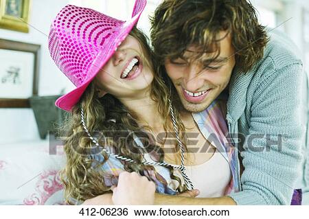 Stock Photograph - Smiling couple playing on sofa. Fotosearch