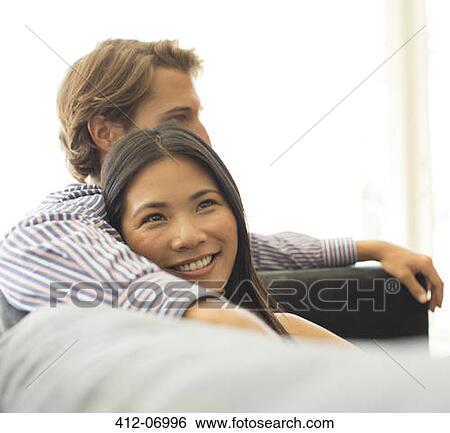 Smiling couple relaxing on sofa View Large Photo Image Stock Photograph - Smiling couple relaxing on sofa. Fotosearch
