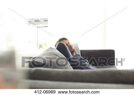 Smiling man relaxing on sofa View Large Photo Image Stock Photo - Smiling man relaxing on sofa. Fotosearch