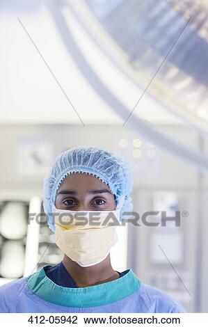 Stock Image - Surgeon standing in operating room. Fotosearch