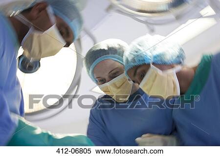 Surgeons bent over patient in operating room View Large Photo Image Stock Photography - Surgeons bent over patient in operating room. Fotosearch