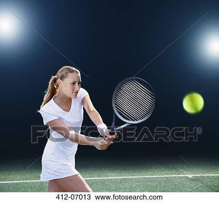 Tennis player hitting ball on court View Large Photo Image Stock Image - Tennis player hitting ball on court. Fotosearch