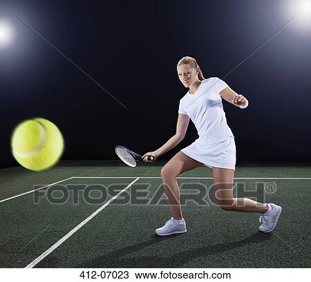 Tennis player hitting ball on court View Large Photo Image Stock Image - Tennis player hitting ball on court. Fotosearch