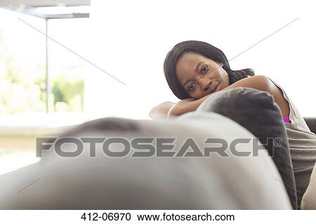 Stock Image - Woman relaxing on sofa. Fotosearch