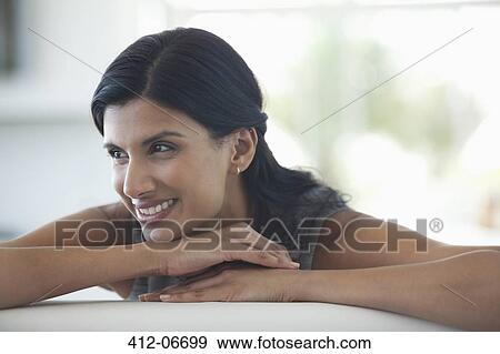 Woman resting chin in hands on sofa View Large Photo Image Stock Photo - Woman resting chin in hands on sofa. Fotosearch