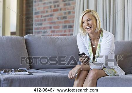 Woman using cell phone on sofa View Large Photo Image Stock Photo - Woman using cell phone on sofa. Fotosearch