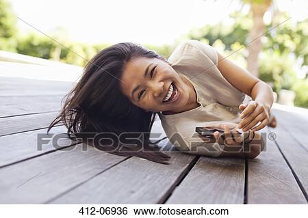 Woman using cell phone on wooden deck View Large Photo Image Stock Photograph - Woman using cell phone on wooden deck. Fotosearch