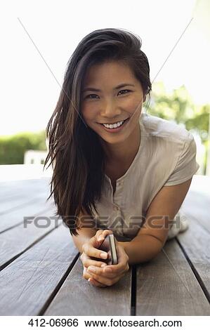 Woman using cell phone on wooden deck View Large Photo Image Stock Photograph - Woman using cell phone on wooden deck. Fotosearch