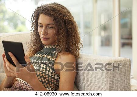 Woman using tablet computer on sofa View Large Photo Image Stock Image - Woman using tablet computer on sofa. Fotosearch