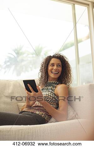 Woman using tablet computer on sofa View Large Photo Image Stock Image - Woman using tablet computer on sofa. Fotosearch