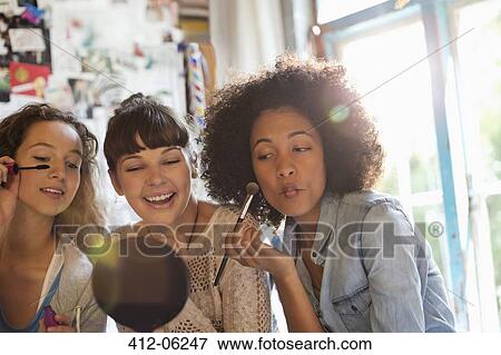 Stock Photo - Women applying makeup in bedroom. Fotosearch