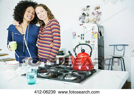 Women hugging in kitchen View Large Photo Image Stock Photo - Women hugging in kitchen. Fotosearch