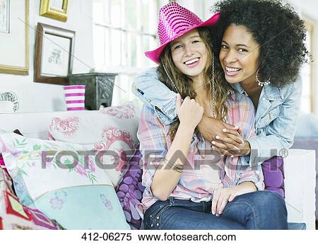 Women hugging in living room View Large Photo Image Stock Photography - Women hugging in living room. Fotosearch