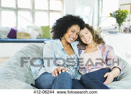 Women sitting in beanbag chair together View Large Photo Image Picture - Women sitting in beanbag chair together. Fotosearch